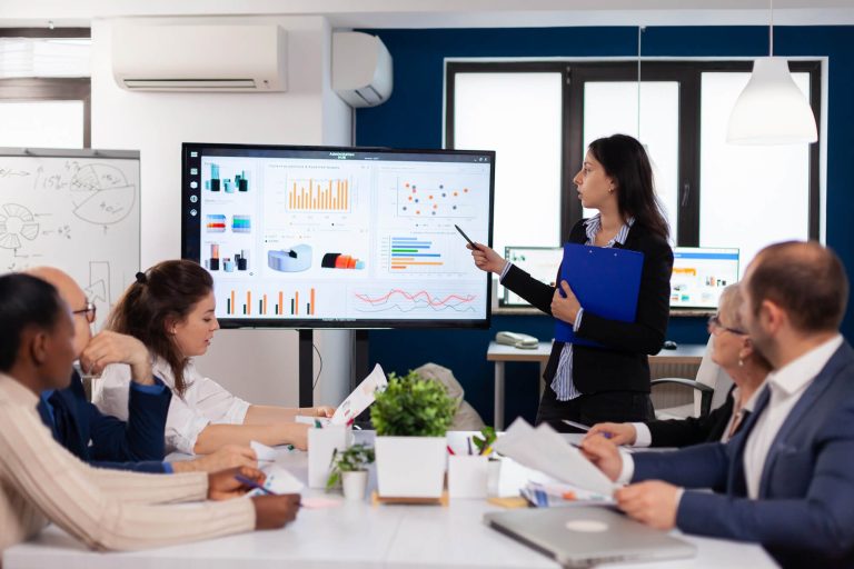 young-team-leader-big-corporation-briefing-coworkers-pointing-graph-meeting-corporate-staff