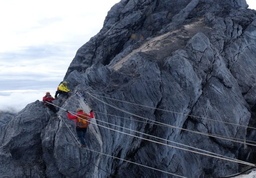 A climber on the rope bridge near the summit.