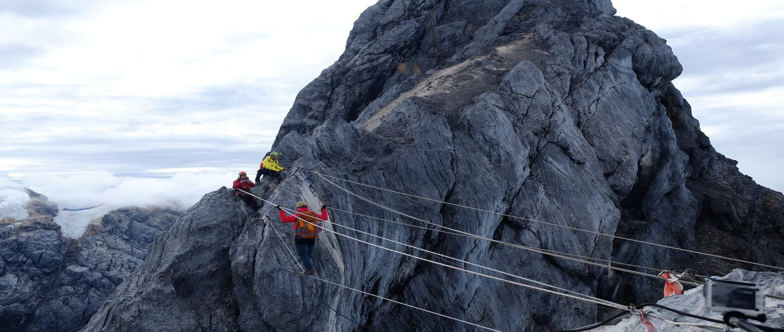 A climber on the rope bridge near the summit.